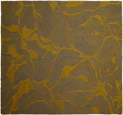 A square textile or rug with an abstract topographic pattern in mustard yellow and slate blue-gray, filling the entire frame.