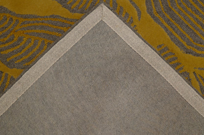 Close-up of a rug corner showing a large light gray triangular section meeting a mustard yellow and gray patterned section, with a beige border between them.