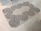 Indoor/Outdoor Ivory Rug with Black Geometric Swirl and Live Edge Design.