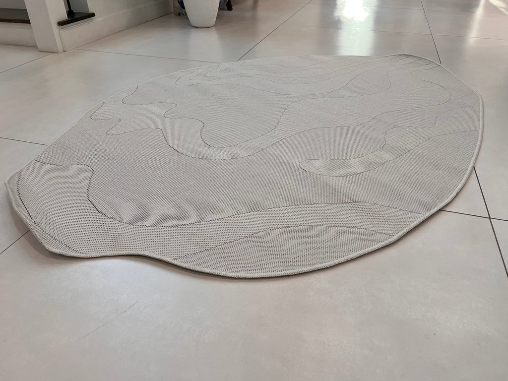 Ivory Indoor/Outdoor Rug with Organic Irregular Shape and Warm Mocha Accents.