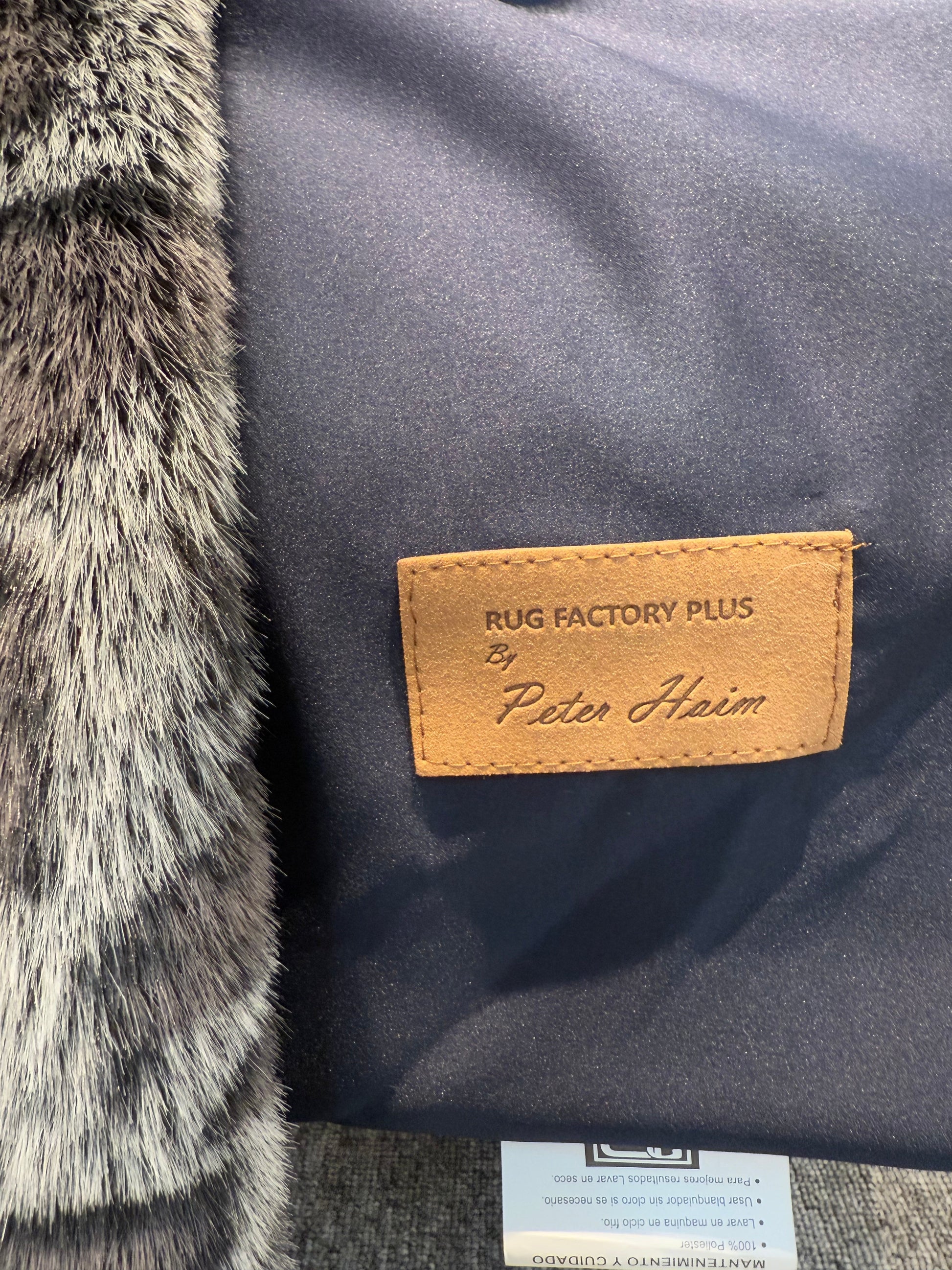 Close-up of a rug with a brand label on a textured surface