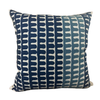 A square-shaped throw pillow with a geometric pattern in blue and white colors, featuring a solid back.