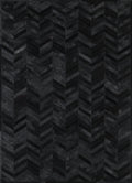 A close-up view of a black patchwork cowhide rug with a geometric pattern.